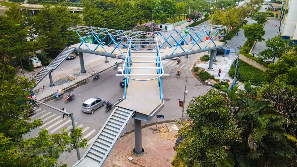 Son Tung, habitant dans l’arrondissement de Thanh Xuan, a dit : "La plupart des viaducs pour piétons à Hanoï ont une conception simple. C'est la première fois que je vois un ouvrage avec un design aussi unique. J'espère que ce viaduc contribuera à aider les gens à traverser la rue en toute sécurité et à économiser du temps de déplacement”. Il s'agit d'une belle construction, considérée comme ayant le plus beau design parmi les ponts piétonniers actuels de la capitale vietnamienne. Les travaux devraient être achevés au deuxième trimestre de cette année. Se promenant souvent ici, Dao Ngo Bao Phuc a partagé : “Je trouve qu'il est nécessaire d'installer un viaduc dans cette zone. Parce qu'il assurera notre sécurité à chaque fois que nous traversons la route”. Photo: VietnamPlus
