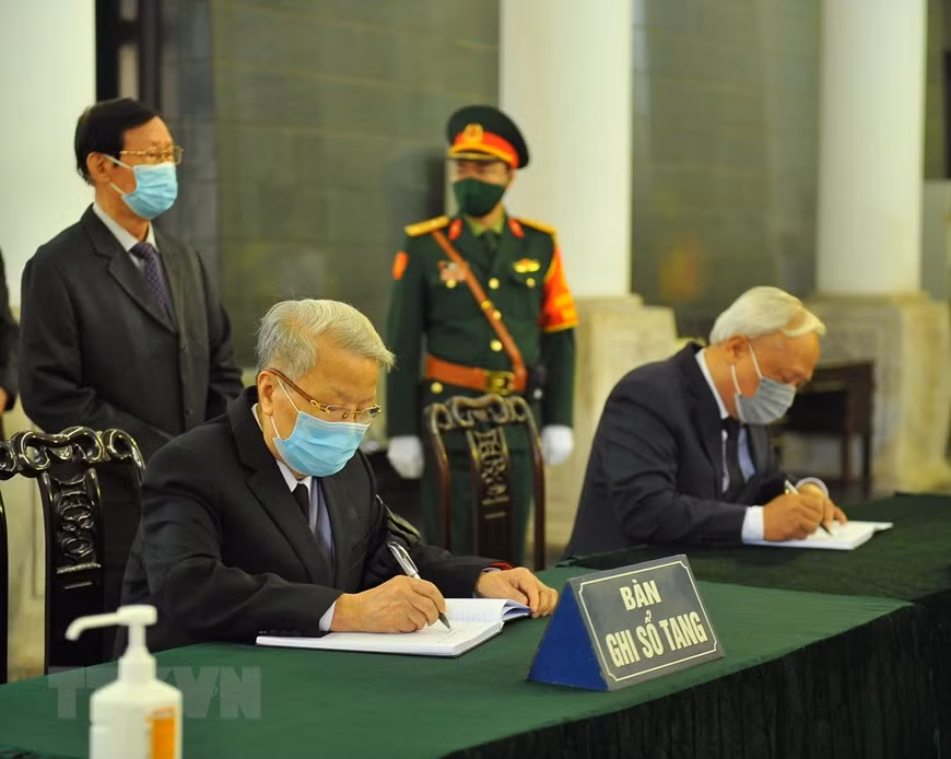L'ancien président vietnamien Tran Duc Luong (gauche) et le vice-président de l'Assemblée nationale Uong Chu Luu écrivent le registre de deuil. Photo : VNA 