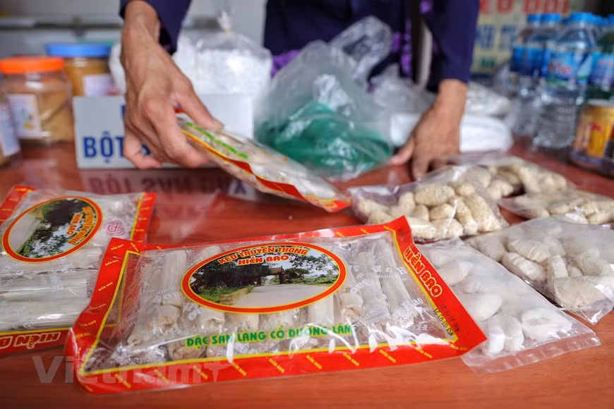 La cuisine vietnamienne varie d'une région à l'autre et le village de Duong Lam possède sa propre liste d'aliments locaux uniques. Le « Keo doi » (bonbon à la saucisse et aux arachides) et le « keo lac » (bonbon aux arachides) sont parmi les spécialités les plus populaires ici. Il est facile de trouver les ingrédients pour faire le « keo doi » comme l'arachide, le malt et le sucre. Une fois qu'ils ont essayé le « keo doi », les visiteurs peuvent ressentir le goût de noisette de l'arachide et le parfum de la farine de riz gluant. Pendant ce temps, « keo lac » est un morceau de la culture vietnamienne et considéré comme l'un des cadeaux importants pour les visiteurs. Déguster ces types de bonbons avec du thé vert les rendra plus savoureux. Photo: Vietnamplus