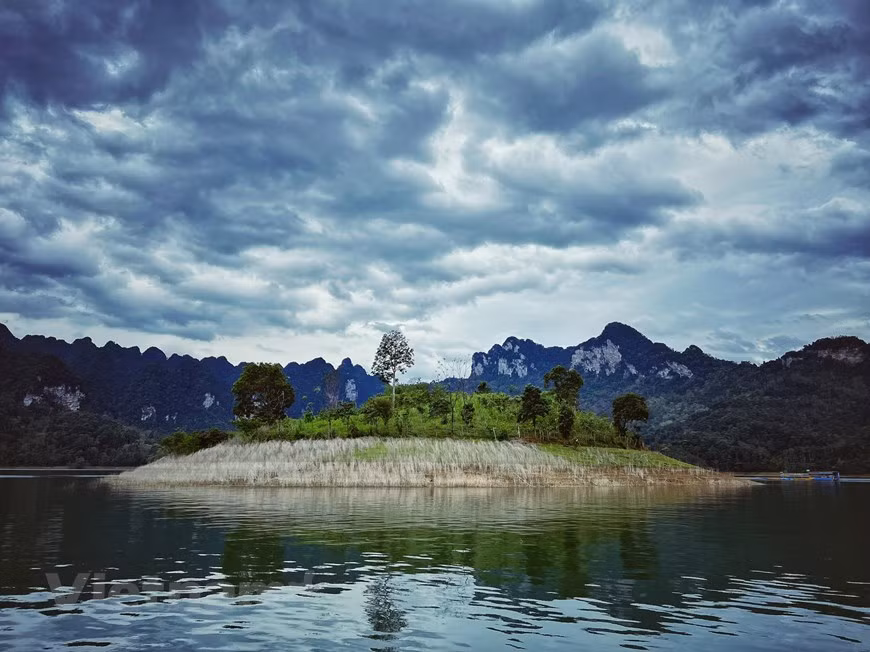 En faisant une excursion en bateau sur le lac à tout moment de la journée, de l'aube au coucher du soleil, les visiteurs peuvent respirer l'atmosphère pure et admirer la beauté vierge et mystérieuse des paysages. Le ciel bleu et les centaines de montagnes environnantes projettent leurs reflets sur la surface lisse de l'eau du lac, créant un panorama pittoresque et tranquille qui peut laisser une forte impression sur les visiteurs. Au petit matin, le lac est enveloppé d'une épaisse couverture de brouillard, les nuages semblent s'attarder d'un côté des montagnes. Lorsque le soleil se lève, la scène apparaît plus clairement, avec un ciel bleu cristallin et une surface d'eau semblable à un miroir. Photo: Vietnamplus