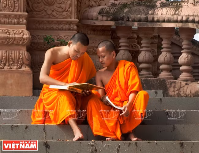 Deux jeunes bouddhistes révisent leurs leçons dans l’enceinte de la pagode.