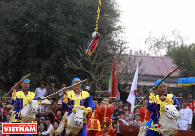 Les hommes doivent abattre une balle suspendue au milieu de l'aire de jeu du festival. 