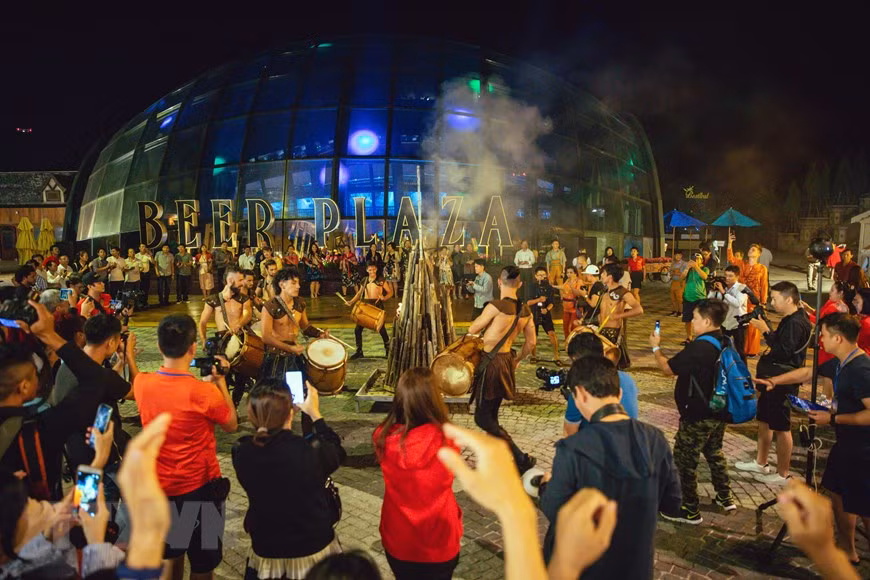 Les touristes participent aux activités culturelles et artistiques dans la zone touristique Ba Na Hills. 