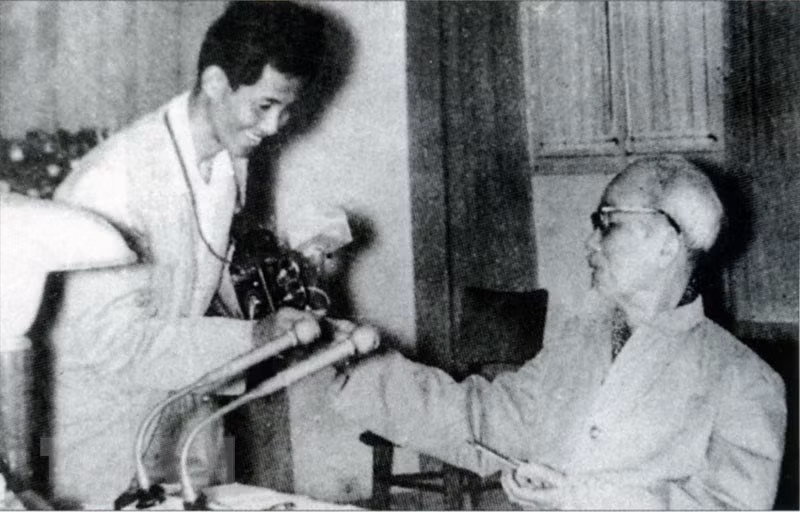 Le Président Hô Chi Minh offre des cigarettes parfumées au journaliste Lam Hong Long - l'auteur d'une célèbre photo "Bác bắt nhịp Bài ca Kết đoàn" (L'Oncle Hô bat la mesure de la chanson de solidarité). 