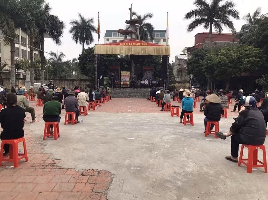 Des personnes défavorables à Hai Duong (Nord) maintiennent leur distance pour recevoir du riz. Photo: VNA 