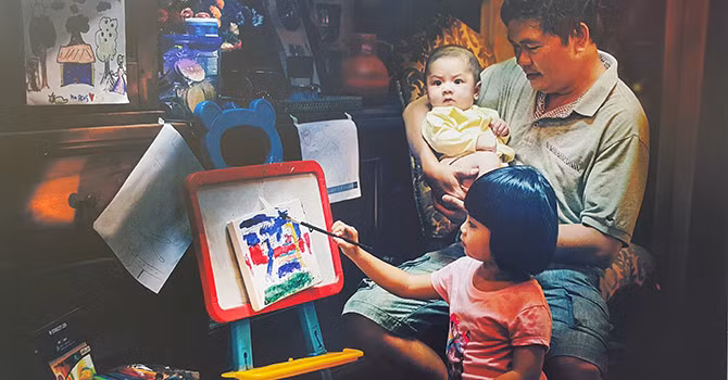 Un père enseigne à son enfant à dessiner.