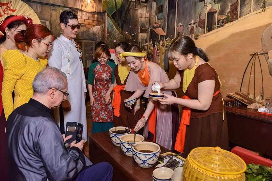 Les invités sont traités avec des plats traditionnels du Têt. Le Têt permet de se retrouver en famille. Plus les plateaux sont riches, plus cela exprime le respect envers les ancêtres. Les plateaux traditionnels du Nouvel An vietnamien se composent de nombreux mets et symbolisent tous divers souhaits et vœux de chaque famille pour la nouvelle année. Les plateaux du Têt sont également très colorés : le vert du bánh chung mélangé au rouge du riz gluant cuit avec de la pulpe de la momordique en passant par le jaune des pousses de bambou au rose du pâté de porc... Le plateau traditionnel du Têt des Vietnamiens des trois régions (Nord - Centre - Sud) montre la diversité dans l’unité. Celui du Nord a toujours du bánh chung, tandis que ceux du Centre et du Sud, du bánh tét. Chaque plat déposé sur le plateau du Têt est préparé méticuleusement avec des ingrédients qui se combinent harmonieusement et des épices caractéristiques de chaque région, valorisant la diversité de la culture culinaire et une identité nationale puissante. Photo: Vietnam+