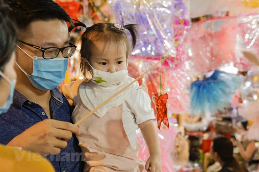 À Hanoi, depuis un mois, les rues Luong Van Can, Hàng Ma, Hàng Luoc, Hàng Cân et le marché Dông Xuân, dans le Vieux quartier de la ville, ont un air de fête. Depuis une semaine déjà, enfants et adolescents s’y pressent chaque soir, lorsque la ville revêt ses habits de lumière. Un monde féérique qui réjouit amis et parents. Les magasins regorgent de jouets aux couleurs vives et les étalages de gâteaux traditionnels achèvent de donner une ambiance festive aux rues de la capitale. Les lanternes, emblématiques de cette fête, trônent un peu partout. Elles sont en forme d’étoile, de ballon, de poisson, de crapaud... 