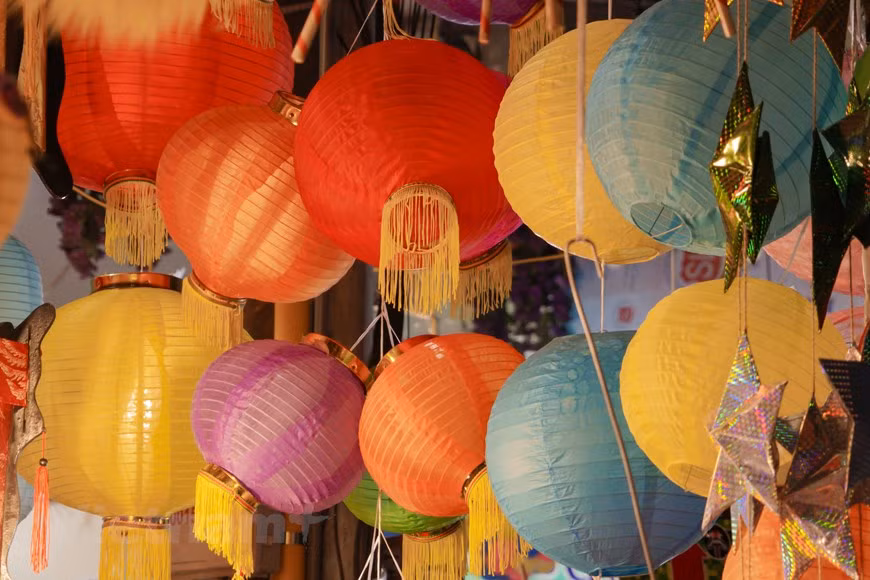 Quand nuit étend son scintillant manteau noir, la rue Hàng Ma s’illumine par la magie des lanternes de fabrication vietnamienne, sans oublier les tambours en bois, têtes de licornes et masques en carton qui emplissent les étals des commerçants... Les jouets en papier ne sont pas en reste : tête de licorne, effigie des docteurs des concours mandarinaux, masques, etc. Une multitude d’objets artisanaux fascinent les enfants : bateaux, paniers aux oiseaux, etc. Ces jouets rappellent les processions aux lanternes d’autrefois et les danses de la licorne. Les jouets modernes comme robots, voitures, motos, avions, téléphones mobiles ont aussi la cote auprès des petits.