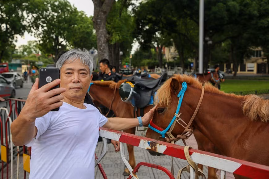 Dès la bonne matinée du 8 juin, un grand nombre d'habitants de la capitale étaient présents dans le lieu où l'équipe de Police mobile à cheval se préparait pour son défilé pour prendre des photos avec la cavalerie. Le colonel Nguyen Huy Hanh, chef de la force de police, a déclaré que celle-ci avait activement conseillé au commandement de la Police mobile pour organiser des entraînements dans le but de participer au défilé ainsi qu'à l'accueil des dirigeants du Parti et de l'État venant à cet événement. Les forces de sécurité publique sont chargées de la lutte contre la criminalité, tandis que les garde-frontières et les douanes sont responsables de la prévention du trafic de drogue dans les zones frontalières et les ports. Donc, ils ne doivent pas s'acquitter de cette tâche pour séparé, a –t-il noté. Photo : Minh Son/VietnamPlus 