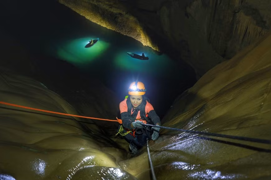 A une profondeur d’environ de 100m, il faut utiliser des lampes frontales pour favoriser son parcours à la conquête de la grotte Son Doong, la plus grande caverne de la planète située dans le parc national de Phong Nha - Ke Bang, dans la province centrale de Quang Binh. La montée nécessite un équipement spécial et pour les 20 premiers mètres, les explorateurs sont soutenus par une solide échelle en métal précédemment positionnée par le conseil de gestion du parc national. Après la première étape, H hen Nie et tous les membres de l’équipe d’explorateurs doivent ensuite se balancer sur une corde pour relever le défi. Photo : Hai An/Vietnam+ 