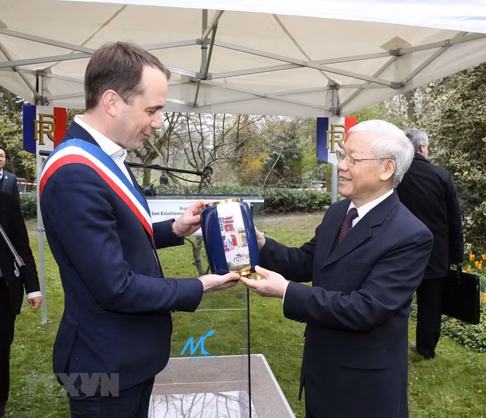 Le secrétaire général du PCV Nguyên Phu Trong offre un cadeau au maire de la ville, Patrice Bessac.