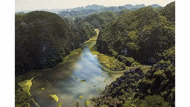 La rivière Hoàng Long est une grande rivière et l'une des quatre voies navigables nationales de la province de Ninh Binh. La rivière est prise à partir de la confluence entre la rivière Bôi et la rivière Lang de Kênh Gà au pont Gian Khâu. La section appelée rivière Hoàng Long fait environ 25 km de longue, étant située dans la zone de dérivation des crues du bassin de Nho Quan. Le bassin de la rivière Hoàng Long couvre la moitié du Nord de Ninh Binh, dont Nho Quan, Gia Viên et Hoa Lu, et la ville de Ninh Binh. Tam Côc, Ninh Binh, vu de la montagne de Ma Yên. Photo : Dan Rochelle.