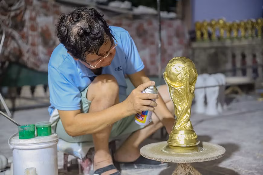 L'atelier de Tran Duc Hai dans le village de poterie de Bat Trang s’accélère la fabrication de nombreux modèles de trophées pour servir les fans du ballon rond. 