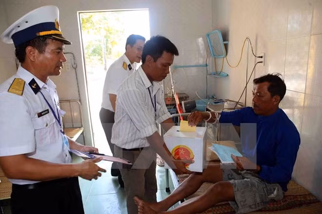 Un pêcheur de la province de Binh Thuan dans l'infirmerie de l'île de Song Tu Tay réalise son droit et devoir de vote. 