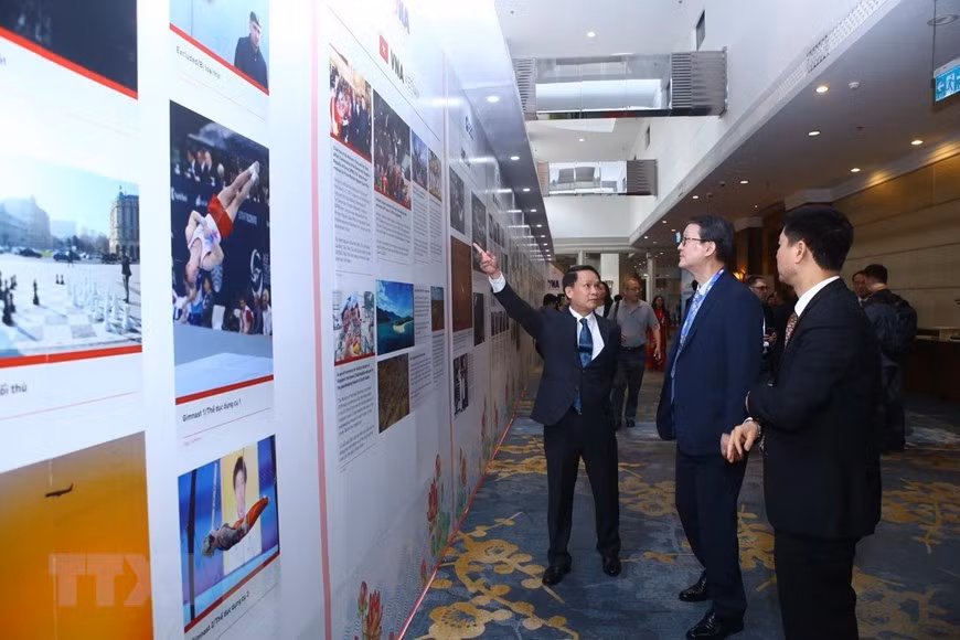 Le directeur général de VNA, Nguyen Duc Loi, et les délégués ont regardé les photos présentant les agences de presse membres de l'OANA. Photo: VNA 