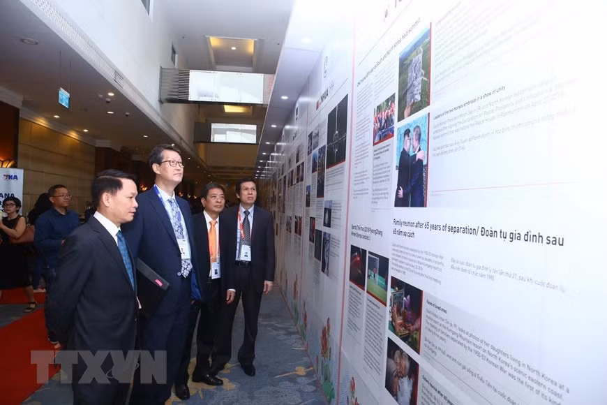 Le directeur général de la VNA, Nguyên Duc Loi, et les délégués regardent des informations sur les agences de presse membres de l'OANA. Photo: VNA 