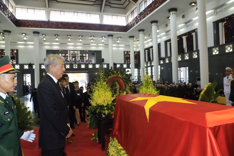 Le vice-Premier ministre singapourien Teo Chee Hean à côté du cercueil du président Trân Dai Quang