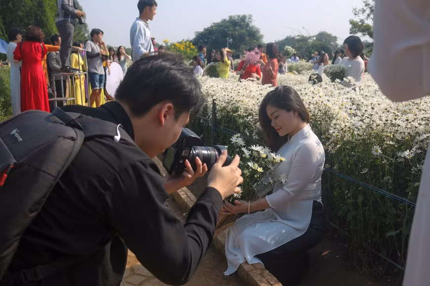 La jeune Do Thi Phuong, originaire de la province de Ha Nam, à 70 km de Hanoï a parcouru une longue distance pour venir au jardin de marguerites Daysi à Song Hong pour prendre des photos. Photo : Thu Uyen/Vietnam+