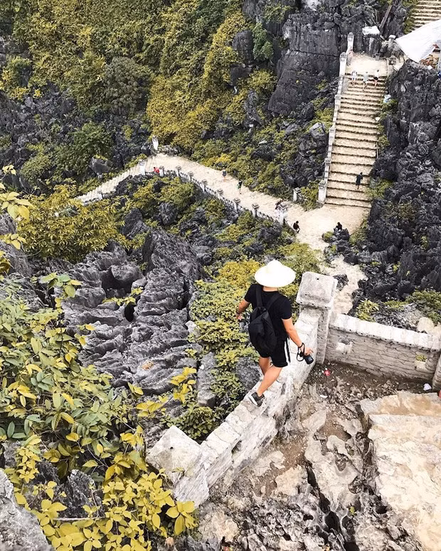 Photo: Vietnamplus Il y a une colline rocheuse parsemée de près de 500 marches menant au sommet couvert de tours, le faisant ressembler à une grande muraille miniature. Les deux côtés de la route sont décorés de statues en pierre sophistiquées de dragons et de phénix construites dans le style de la dynastie des Trân (1225-1400). Les touristes qui se rendent à cet endroit tentent souvent de conquérir le sommet de la montagne, ce qui les amènera à l’une des vues les plus emblématiques du Vietnam - une vue panoramique sur de pittoresques chaînes de montagnes calcaires et des rizières.