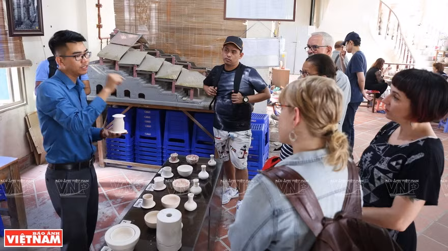 Des visiteurs étrangers dans un atelier de céramiques.