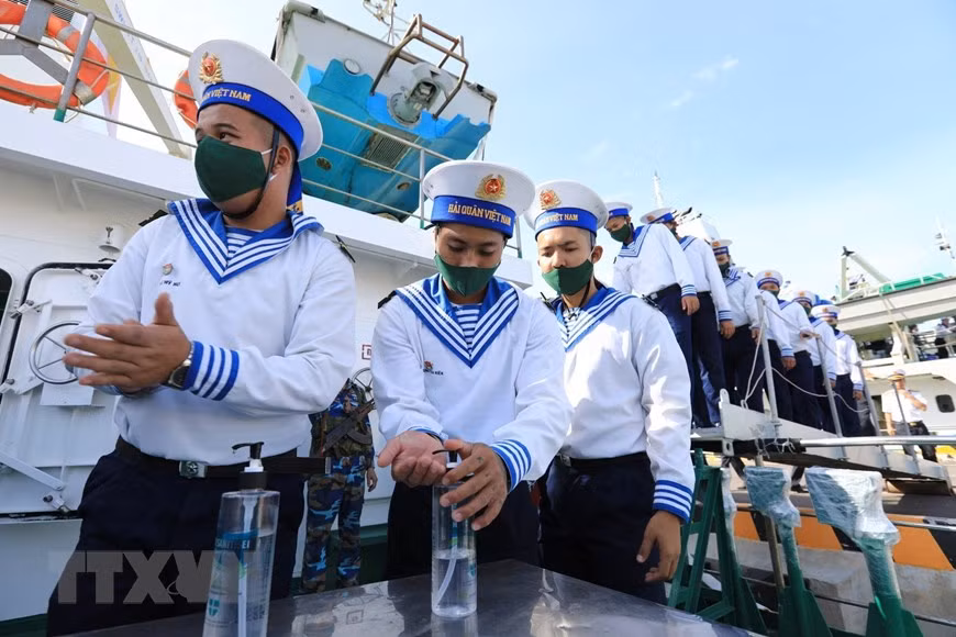 Les soldats de la marine se lavent les mains avec un désinfectant pour prévenir le COVID-19 avant de monter à bord. 
