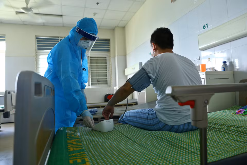 Un médecin examine la santé d'un patient de COVID-19 à l'Hôpital national des maladies tropicales N°2 à Dong Anh, à Hanoï.