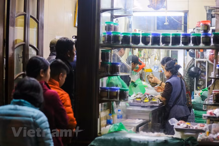 Selon le propriétaire de Quoc Huong, seulement environ 500 banh chung sont transférés au magasin dans le matin du 30e jour du 12e mois lunaire. En particulier, chaque banh chung est vendu au prix de 70.000 dôngs. Les prix des autres produits alimentaires du magasin comme thit bo kho (viande de boeuf séchée), nem chua (sorte de viande de porc fermentée enveloppée dans une feuille de bananier), gio cha (pâté de porc),... restent inchangés. Les saveurs traditionnelles des produits alimentaires du magasin Quoc Huong sont très appréciées par les Hanoïens, notamment des personnes âgées. C'est pourquoi le magasin est toujours bondé à chaque Nouvel An lunaire. Photo: Vietnam+