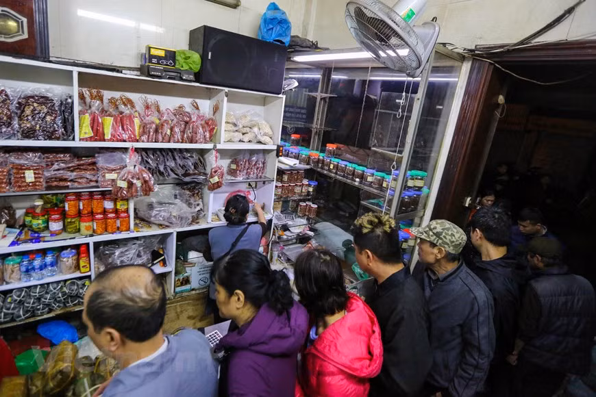 Une semaine avant le Têt, les files d'attente commencent à se former à l'extérieur du magasin situé au milieu du Vieux quartier de Hanoï. Les fans appellent Quoc Huong "le magasin de la période de l'économie subventionnée ", se souvenant du moment où les habitants de Hanoï faisaient régulièrement la queue pour acheter de la nourriture en raison des pénuries au cours de la période 1975-1986. Pour beaucoup de gens, la période de l’économie subventionnée (années qui ont précédé le Dôi Moi (Renouveau en 1986) est associée à la pénurie matérielle et à la débrouille pour survivre. C’est le temps où tous les biens étaient distribués, où tout le monde faisait la queue avec des tickets de rationnement, des carnets de riz. Photo: Vietnam+
