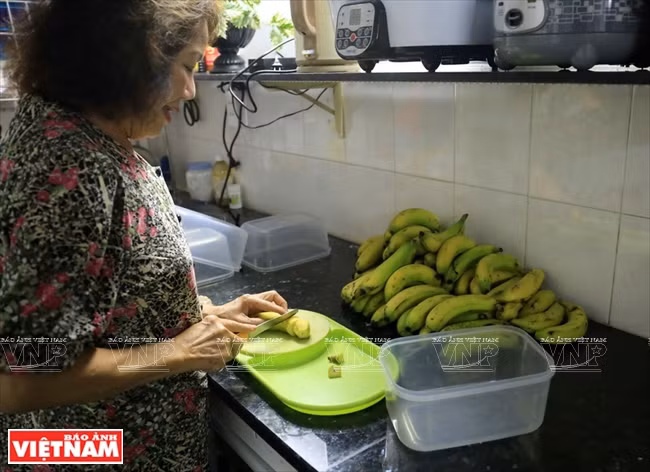 Nguyên Thi Liêu préparant des bananes pour les apporter aux écureuils.