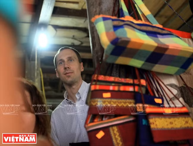 Le touriste américain Brian Bean est intéressé par les produits en brocart des Thai au village de Xiêng