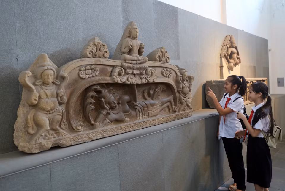 Elèves de Da Nang examinant le bas-relief "Naissance de Brahma", un Trésor national reconnu en 2024. Photo : VNA 