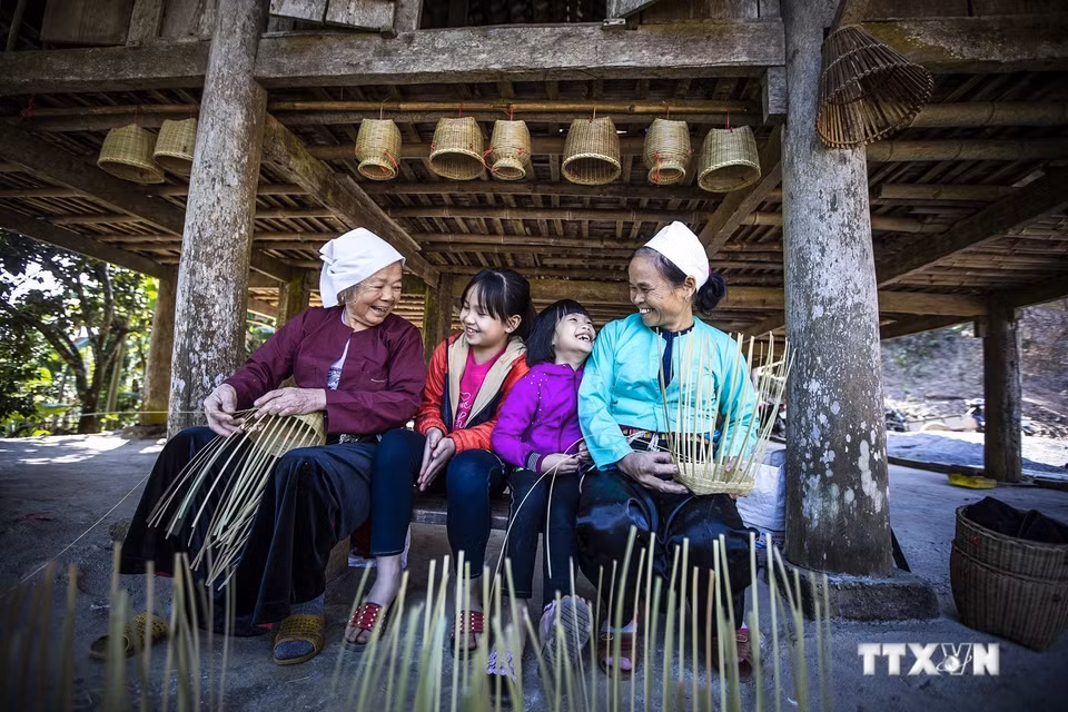  Elles portent parfois le costume traditionnel dans leur vie quotidienne. Photo : VNA 