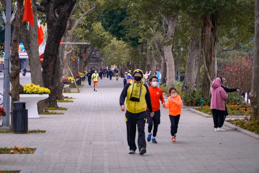 Dans un monde en évolution rapide, les Hanoïens peuvent désormais ralentir et profiter d'une vie au rythme lent pendant une semaine de Têt traditionnel. Se promener autour du lac de Hoan Kiêm le premier jour du Nouvel An lunaire est l'habitude de nombreux habitants locaux. Véritable oasis de quiétude au cœur de la trépidante capitale vietnamienne et de son Vieux Quartier typique, le lac de Hoan Kiêm est un lieu de promenade agréable et reposant, aussi apprécié des Hanoïens que des voyageurs. Il y a aussi quelques personnes qui font du vélo autour du lac en profitant de l'air du petit matin. Photo: VietnamPlus