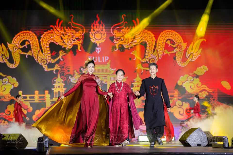 Le designer Dung Nguyen, accompagné de l'Artiste du peuple Thu Quynh et de la présentatrice Mai Ngoc, présente ses "ao dai" (tunique traditionnelle vietnamienne). 
