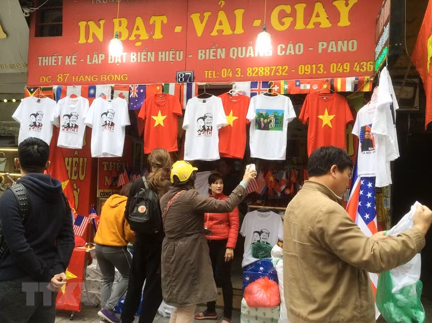  Les visiteurs choisissent des t-shirts à l’image du président américain Donald Trump et du président nord-coréen Kim Jong Un dans un magasin de la rue Hang Bong. 