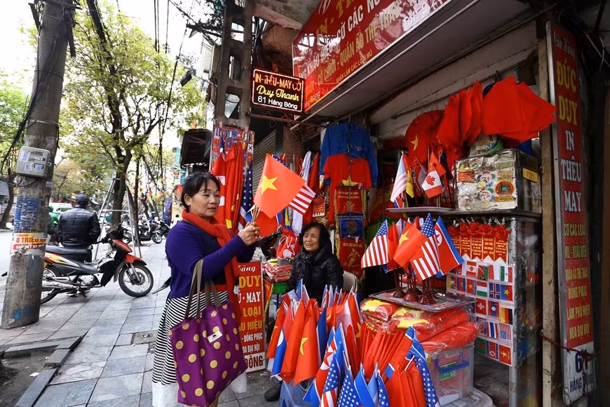  Les touristes achètent des drapeaux des Etats-Unis, de la RPDC et du Vietnam dans la rue Hang Bong. 