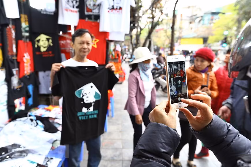  Un visiteur prend une photo avec les t-shirts. 