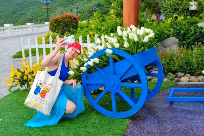  Les tulipes sont joliment agencées le long de la colline de Van Hoa, attirant les touristes vietnamiens et étrangers. 