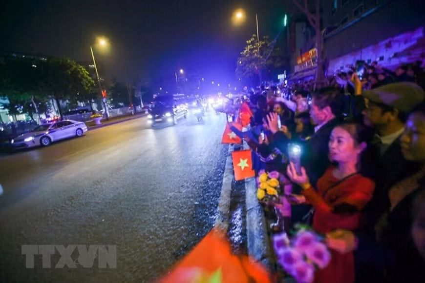 Les habitants de Hanoi avec des drapeaux et des fleurs dans la main sont heureux d’accueillir le président américain Donald Trump. Photo : VNA