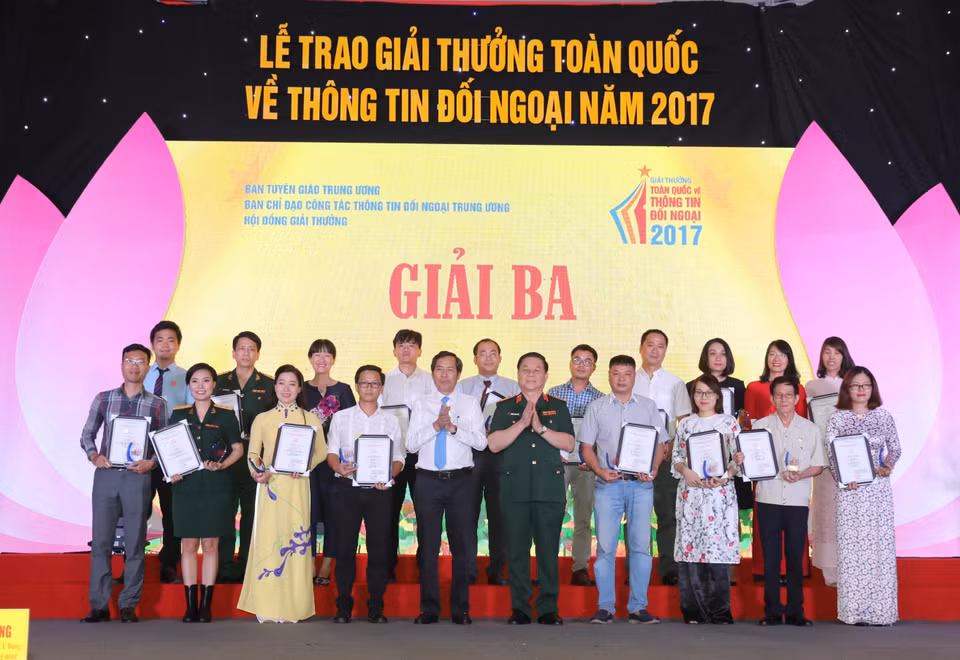 Thuan Huu, rédacteur en chef du journal Nhan Dan et le général de division Nguyen Trong Nghia, chef adjoint du Département général de la politique de l'Armée populaire du Vietnam (centre du premier rang) ont remis le troisième prix 
