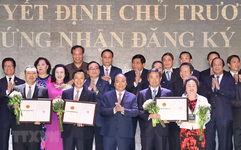 Le Premier ministre Nguyen Xuan Phuc (centre, au premier rang), a remis des décisions et certificats d’investissement à des entreprises 