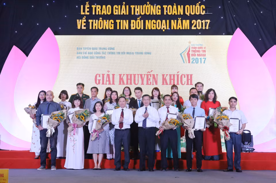 Nguyen Duc Loi et Nguyen Tuan Phong, chef adjoint de la Commission centrale des Relations extérieures du PCV (centre au premier rang) et des lauréats du prix d'encouragement 