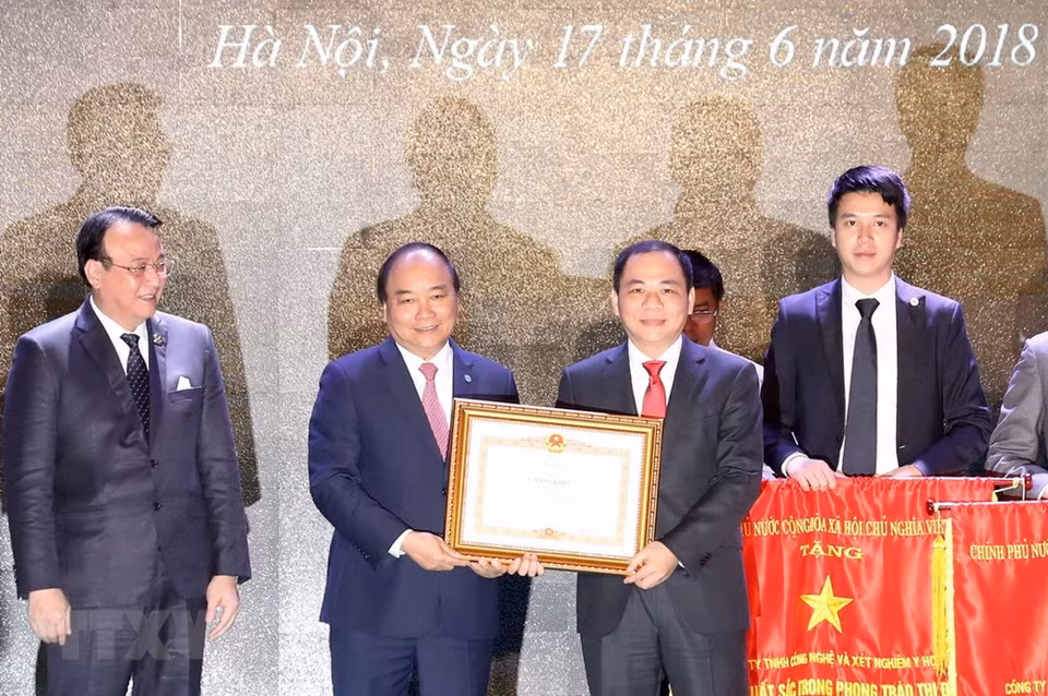 Le Premier ministre Nguyen Xuan Phuc remet des satisfecit et drapeaux d'émulation aux représentants des entreprises ayant eu des contributions remarquables au développement de la capitale 