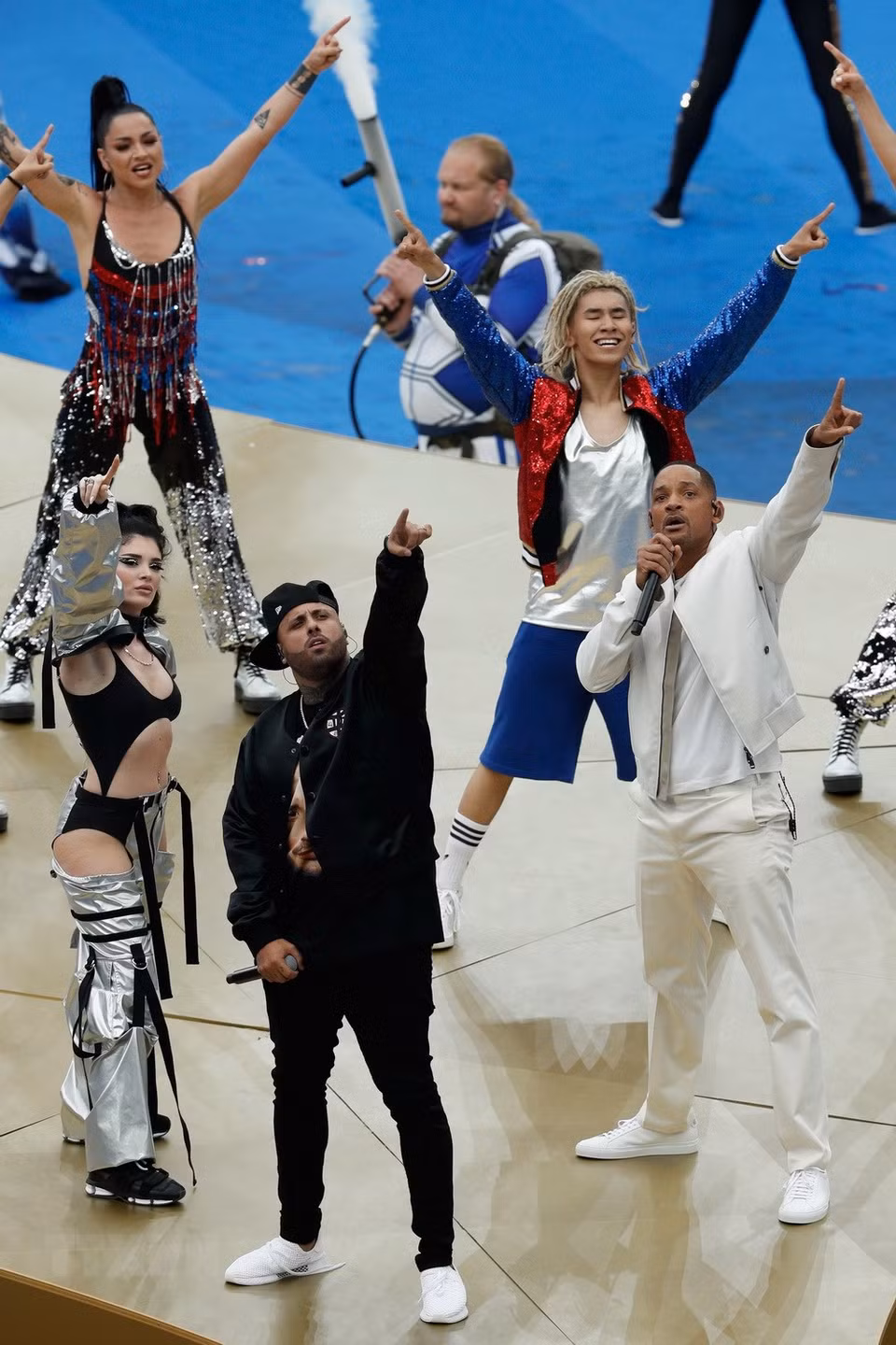  L'acteur américain et rappeur Will Smith (droite), accompagné sur scène de Nicky jam (centre) et d'Era Estref (gauche), ainsi qu'une centaine de danseurs et danseuses sur le terrain, présentent une chorégraphie impressionnante. 
