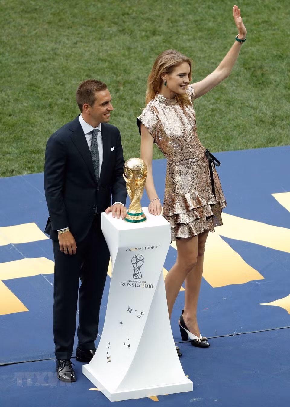  Philipp Lahm, capitaine de l'Allemagne championne du monde en 2014, et Natalia Vodianova, top-modèle russe impliquée dans des initiatives activistes et philanthropiques, apportent le trophée de la Coupe du Monde de la FIFA sur le terrain du stade Loujniki. 