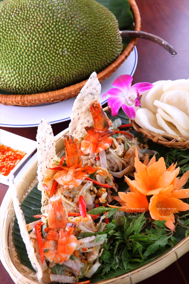 Une salade de fruits du jackier décorée avec l'image de la baie de Ha Long. 