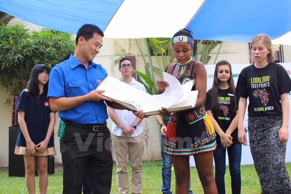 L'ambassadrice sud-africaine de protection des rhinocéros remet un livre sur la protection de ces animaux à un représentant de l'Union de la jeunesse communiste Ho Chi Minh.