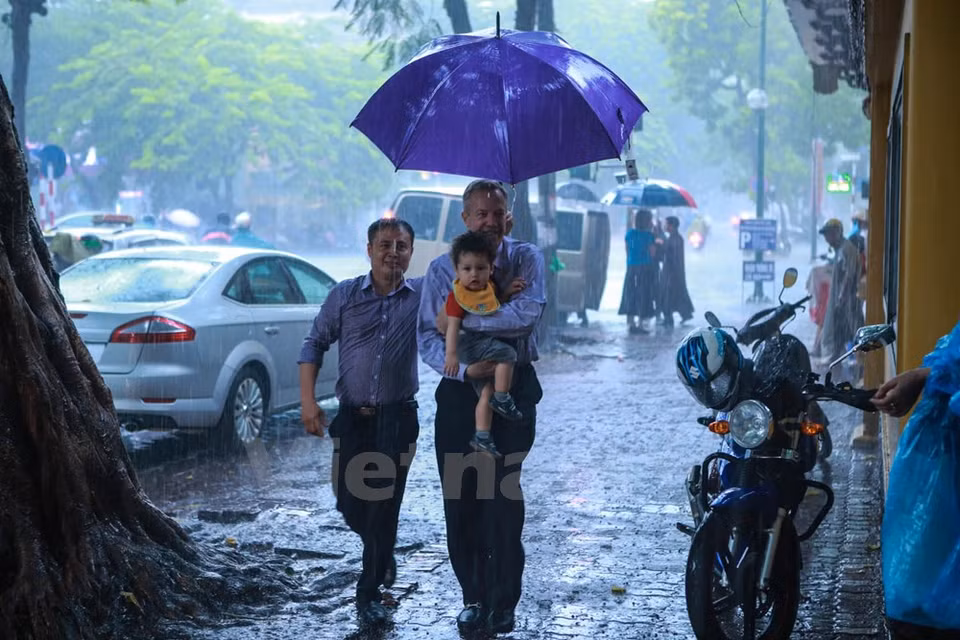 L'ambassadeur des Etats-Unis au Vietnam, Ted Osius, a emmené sa mère, sa sœur et son fils à la pagode Quan Su malgré la pluie. 