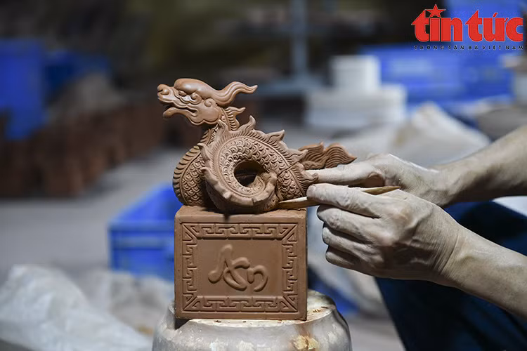 Les artisans du village de céramique de Bat Trang fabriquent des sceaux de dragon plaqués d’or pour le Nouvel An lunaire du Dragon. 
